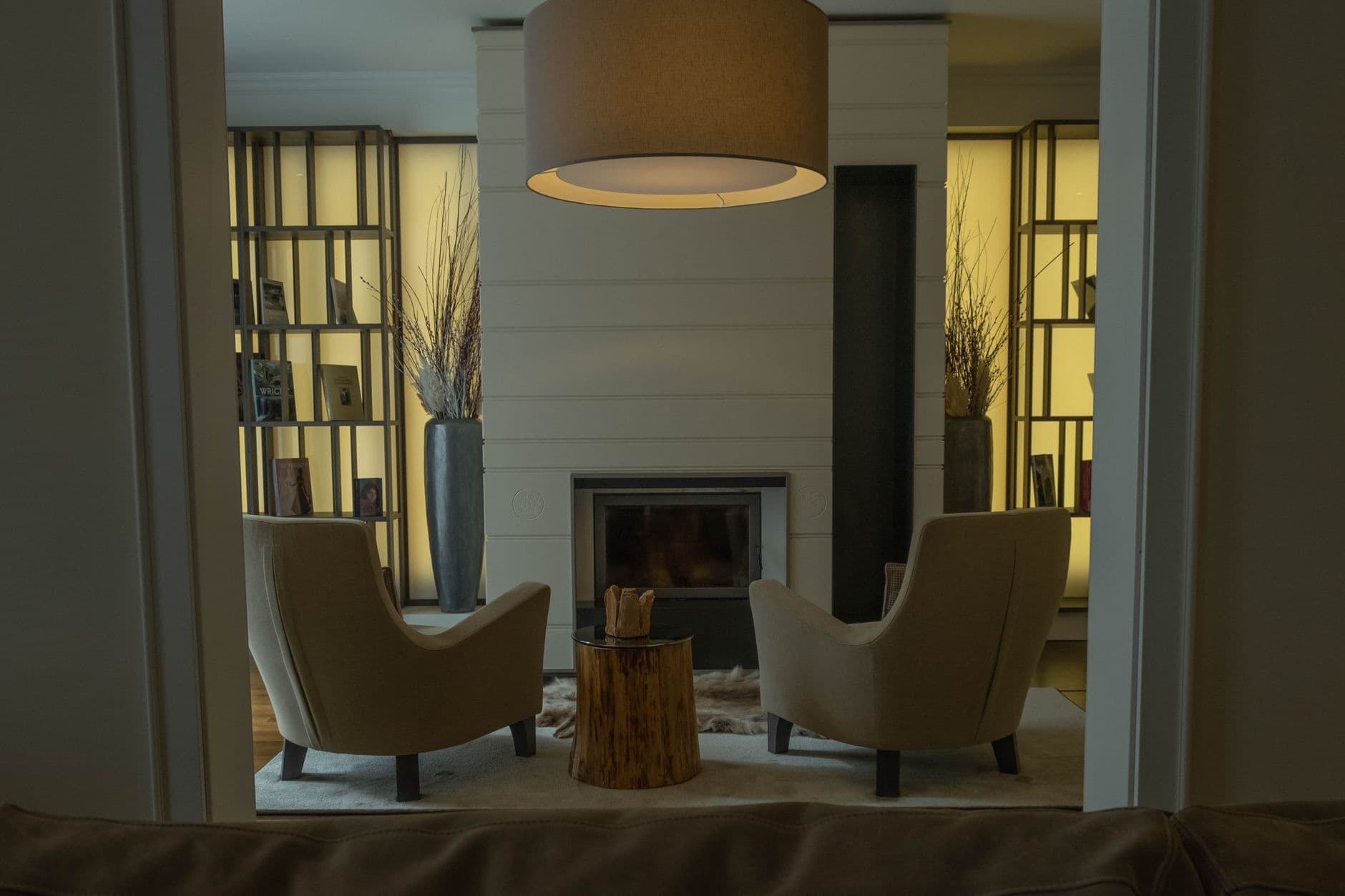Cozy modern living room featuring armchairs, fireplace, and minimalist decor.